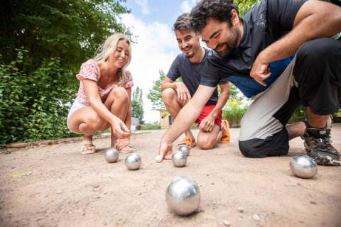 Drei Personen spielen Boule im Freien im Ferienpark Huttopia Lac d'Aureilhan in Frankreich.