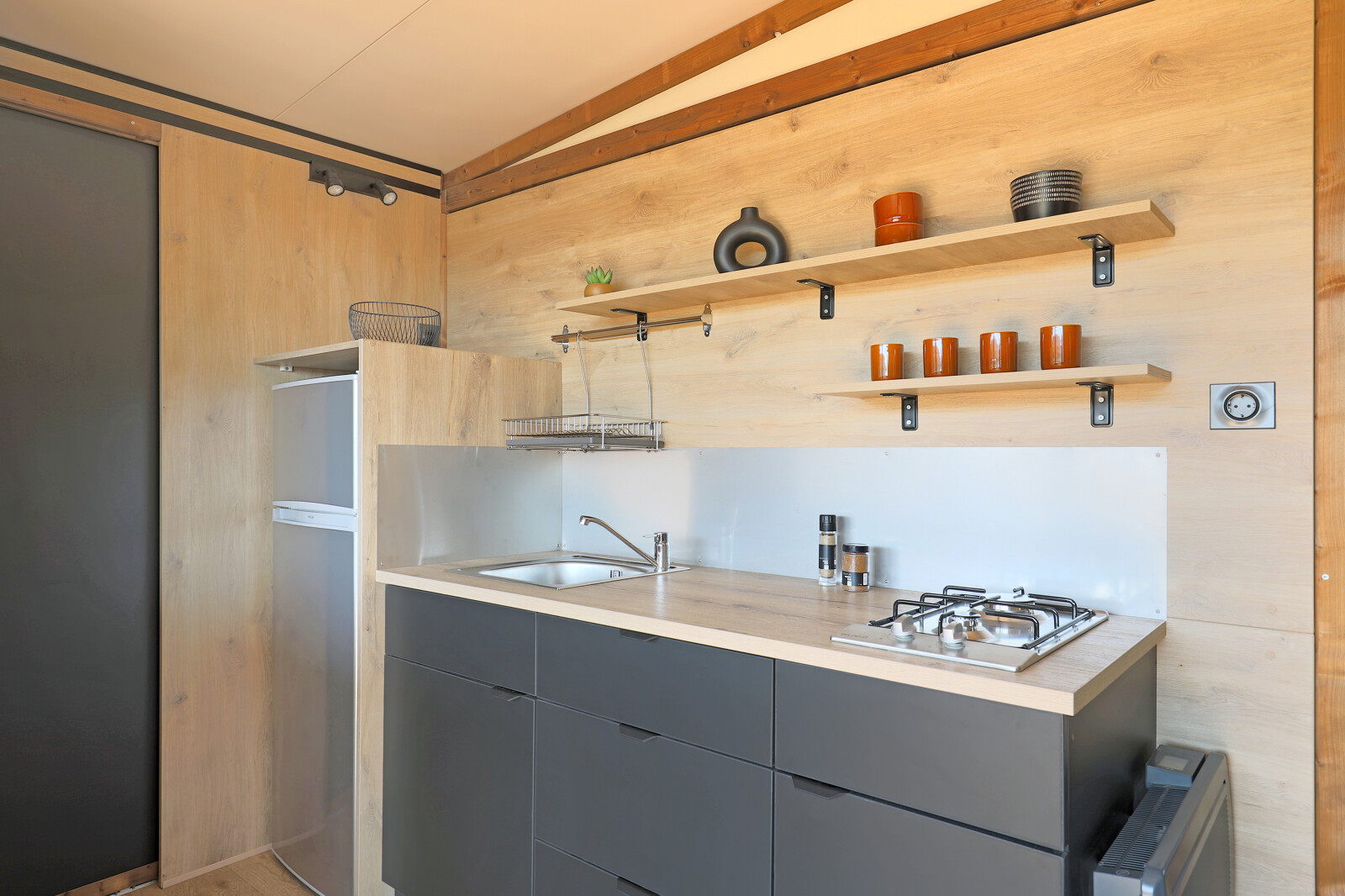 Moderne kitchenette in de safaritent Arizona bij Huttopia Lac d'Aureilhan - Mimizan, Frankrijk, met houtdetails.