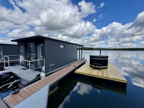 Houseboat at Marina Mookerplas in the Netherlands with a floating deck and outdoor hot tub on the lake.