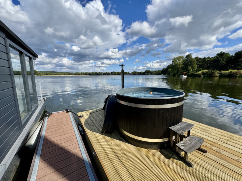 Vista desde Houseboat Marina Mookerplas con bañera de hidromasaje en la cubierta junto al lago en Países Bajos.
