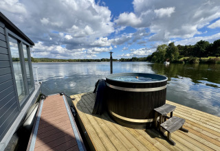 Vista desde Houseboat Marina Mookerplas con bañera de hidromasaje en la cubierta junto al lago en Países Bajos.