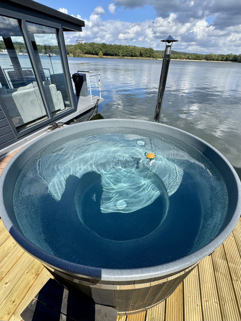 Hottub op het dek van een woonboot bij Marina Mookerplas in Nederland met uitzicht op het water.
