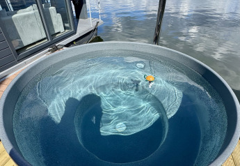 Hottub op het dek van een woonboot bij Marina Mookerplas in Nederland met uitzicht op het water.