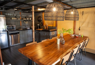 Gezellige eethoek en moderne open keuken in een lodge op vakantiepark Sandberghe, Noord-Brabant, Nederland.