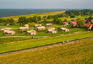 Luchtfoto van Vakantiepark IJsselhof in Noord-Holland met huisjes, gras en uitzicht op het water.