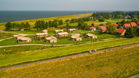 Luftaufnahme vom Vakantiepark IJsselhof in Nordholland mit Hütten und Blick aufs Wasser.
