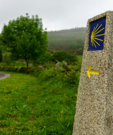 Borne en pierre avec coquille jaune et flèche sur le Camino de Santiago près de Prado, Lalín, Galice, Espagne.