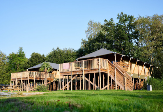 Safari Boomhut mit Sanitäranlagen auf Camping Goorzicht, Niederlande, auf Stelzen im Grünen erbaut.