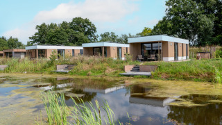 Moderna cabaña acuática con jacuzzi en Hofparken Wiltershaar, Países Bajos, junto a un estanque y naturaleza.