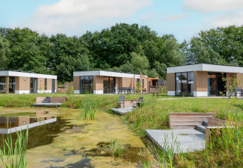 Moderna cabaña acuática con sauna y jacuzzi junto a un estanque, en Hofparken Wiltershaar, Países Bajos.
