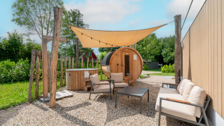 Outdoor lounge with barrel sauna and hot tub at Water lodge 6 Deluxe, Hofparken Wiltershaar, Netherlands