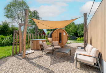 Buitenruimte met barrelsauna en hottub aan Water lodge 6 Deluxe bij Hofparken Wiltershaar, Nederland