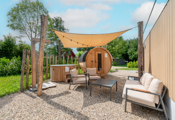 Outdoor lounge with barrel sauna and hot tub at Water lodge 6 Deluxe, Hofparken Wiltershaar, Netherlands