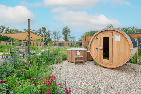 Buitenwellness met sauna en hottub bij Parklodge 4 met hondenhek in Hofparken Wiltershaar, Nederland.