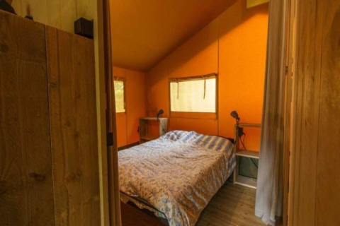 Accogliente camera da letto con letto matrimoniale in una tenda safari con bagno al Parc Koudenburg, Paesi Bassi.