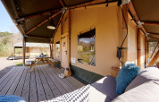 Veranda della Safari Boomhut con divano e tavolo presso Camping Goorzicht nei Paesi Bassi.