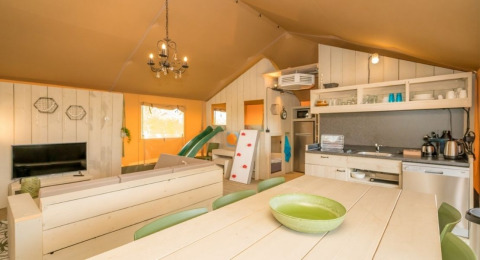 Indvendigt billede af Safaritent Medley på Camping Goorzicht i Holland med køkken, spiseområde og lounge.