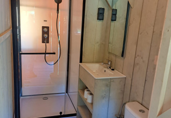 Moderne badkamer met douche, toilet en lavabo in een safaritent op Camping Reiler, Luxemburg.