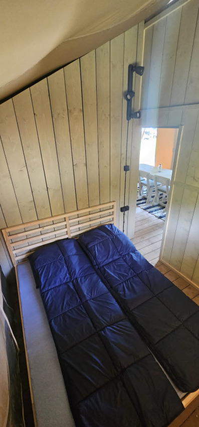 Vista interna di una camera da letto in tenda safari con letti singoli presso Camping Reiler, Lussemburgo.