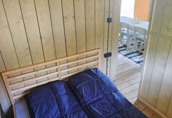 Vista interna di una camera da letto in tenda safari con letti singoli presso Camping Reiler, Lussemburgo.