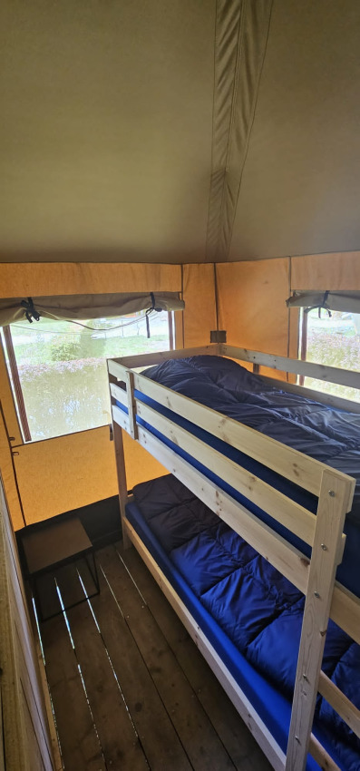 Indvendigt billede af en safariteltseng med køjeseng og vinduer i Camping Reiler, Luxembourg.