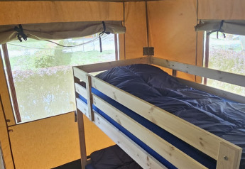 Binnenzicht van een safaritent met stapelbed en ramen bij Camping Reiler in Luxemburg.
