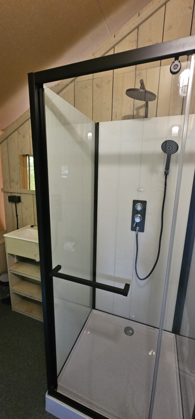 Moderne brusekabine med glasdøre og regnbruser i en safaritelt på Camping Reiler, Luxembourg.