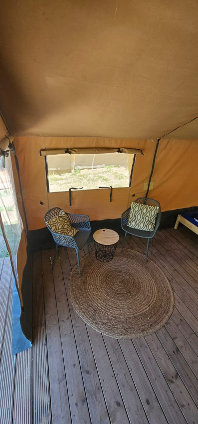 Innenansicht eines Safarizeltes mit zwei Sesseln, Beistelltisch und Teppich bei Camping Reiler in Luxemburg.