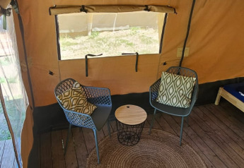 Innenansicht eines Safarizeltes mit zwei Sesseln, Beistelltisch und Teppich bei Camping Reiler in Luxemburg.