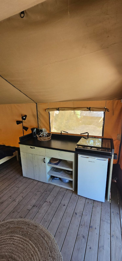 Vue intérieure d'une Safaritent au Camping Reiler au Luxembourg avec kitchenette et sol en bois.