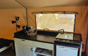 Innenansicht eines Safarizeltes auf dem Campingplatz Reiler in Luxemburg mit Küchenzeile und Holzboden.