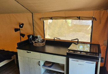 Innenansicht eines Safarizeltes auf dem Campingplatz Reiler in Luxemburg mit Küchenzeile und Holzboden.