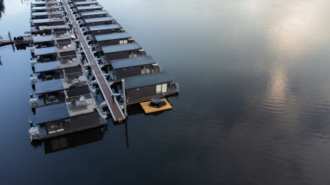 Casa flotante en Marina Mookerplas, Países Bajos, una con jacuzzi en una plataforma sobre el agua.