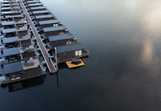 Péniches amarrées à la marina Mookerplas aux Pays-Bas, l'une avec bain à remous sur un ponton flottant.