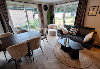 Moderne og hyggelig stue i Groeneborg lodge på Vakantiepark De Wiltzangh i Holland med store vinduer.