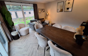 Soggiorno e sala da pranzo alla Groeneborg Lodge di Vakantiepark De Wiltzangh, nei Paesi Bassi, stile moderno.
