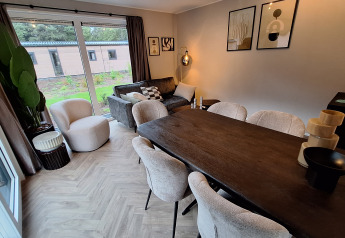 Soggiorno e sala da pranzo alla Groeneborg Lodge di Vakantiepark De Wiltzangh, nei Paesi Bassi, stile moderno.