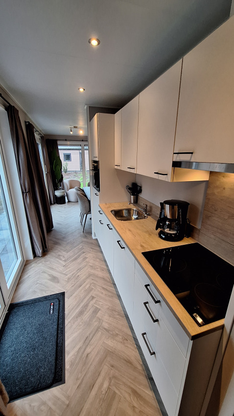Cocina moderna en Groeneborg Lodge, Vakantiepark De Wiltzangh, Países Bajos, con zona de comedor y salón.