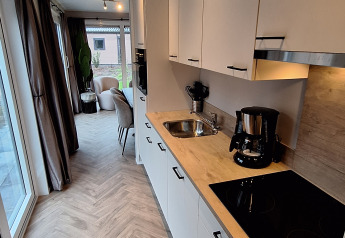 Moderne køkkenområde i Groeneborg Lodge, Vakantiepark De Wiltzangh, Nederlandene, med spiseplads.