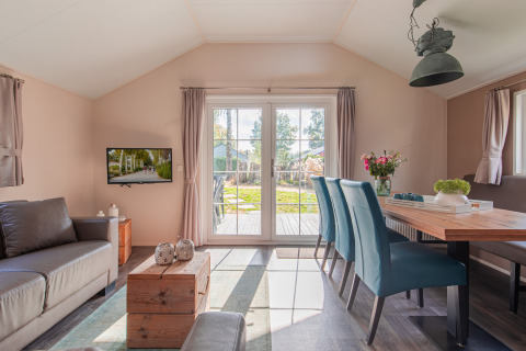 Sala luminosa en Lodge de Vakantiepark Leukermeer, Países Bajos, con muebles modernos y vista al jardín.