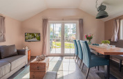 Bright living room at the Lodge, Vakantiepark Leukermeer, Netherlands, with modern furniture and garden view.