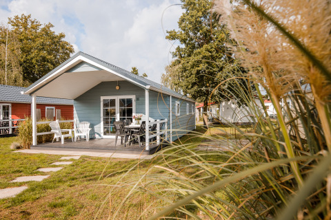 Moderne lodge met terras en tuinmeubilair op Vakantiepark Leukermeer, Nederland, omgeven door groen.