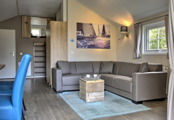 Modern living room at Lodge in Vakantiepark Leukermeer, Netherlands, with corner sofa and sailing photo.