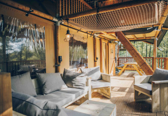 Gemütliche Veranda mit Sitzmöbeln und Netz an einem Safarizelt in Wilsumer Berge, Deutschland.