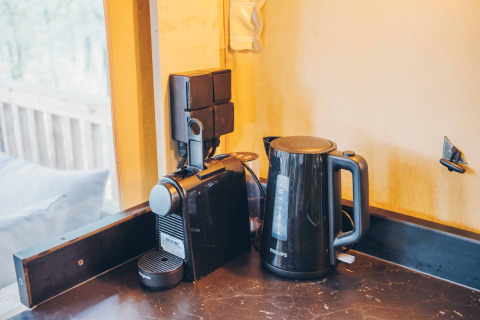 Kaffemaskine og elkedel på køkkenbordet inde i Safari-teltet på Wilsumer Berge, Tyskland.