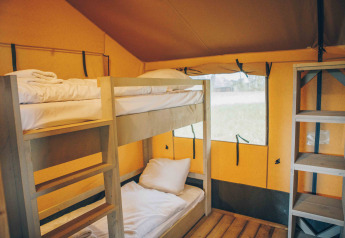 Innenansicht eines Safari-Zeltes im Wilsumer Berge, Deutschland, mit Etagenbett und Holzboden.