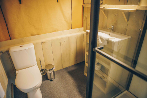 Badeværelse i safaritelt ved Wilsumer Berge, Tyskland, med toilet, håndvask og træindretning.