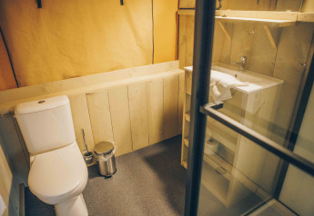 Badeværelse i safaritelt ved Wilsumer Berge, Tyskland, med toilet, håndvask og træindretning.