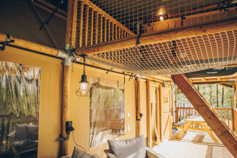 Indvendigt billede af en safariteltsuite med træramme, netloft og udendørs terrasse på Wilsumer Berge.