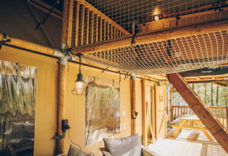 Indvendigt billede af en safariteltsuite med træramme, netloft og udendørs terrasse på Wilsumer Berge.